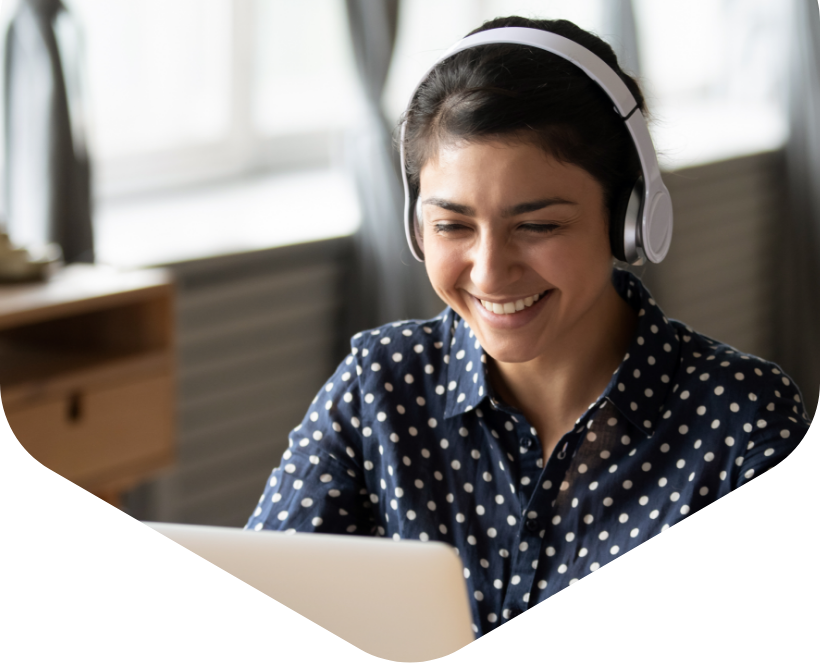 A woman wearing headphones and using a laptop.